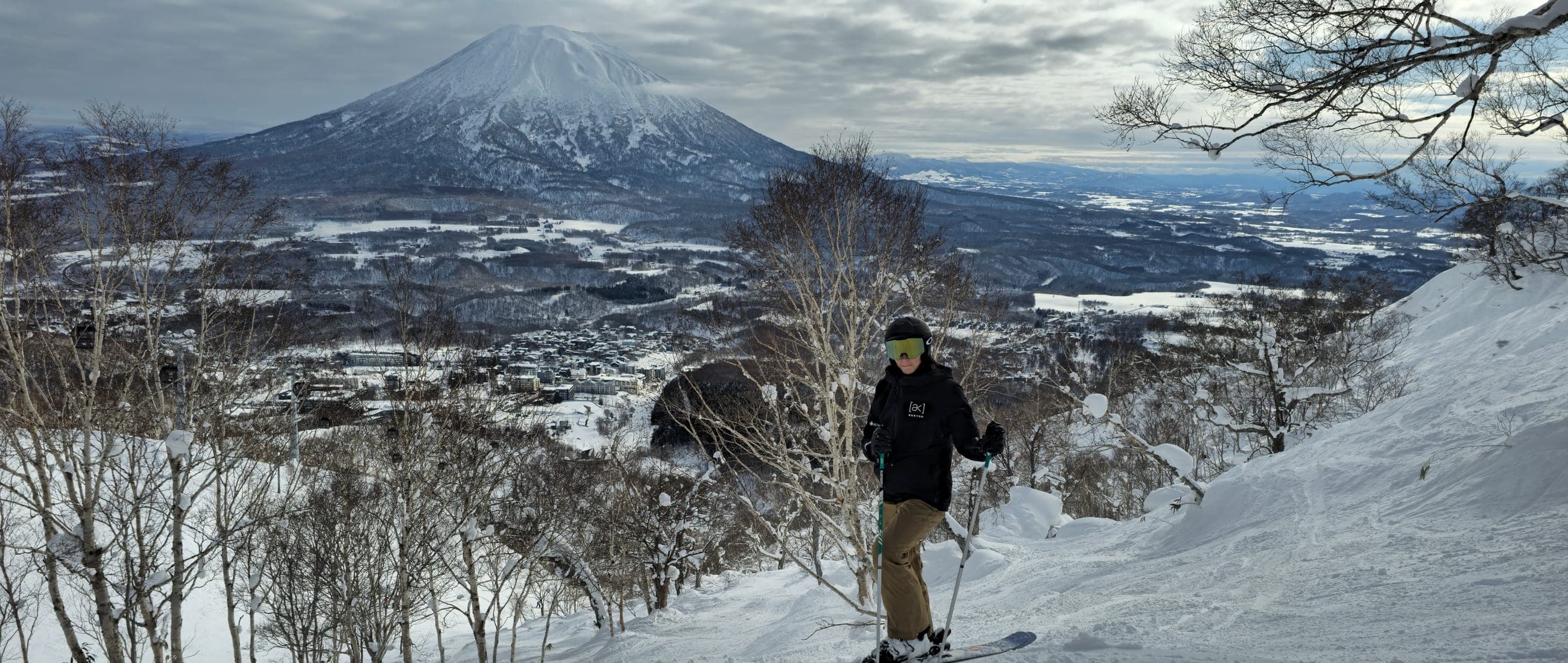 A skier below Mount Yotei above Niseko, Hokkaido, in flat winter light.